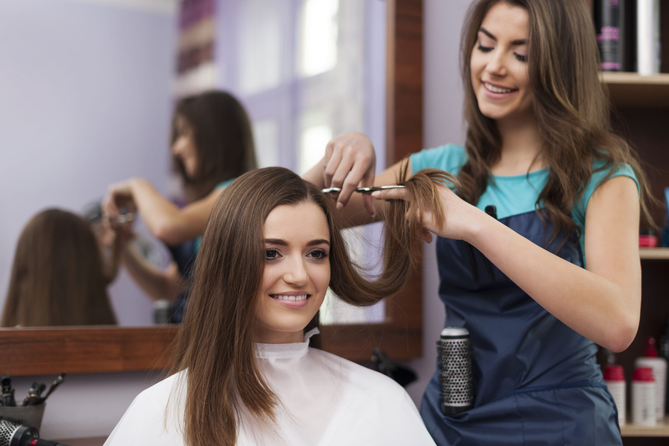 beautiful woman has cutting hair at the hairdresser